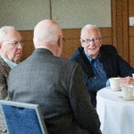 Three men are seated at a table